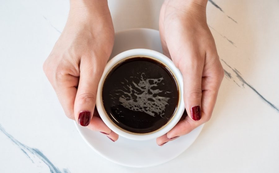 Someone,Hands,Holding,A,Cup,Of,Black,Coffee,Before,Drinking.